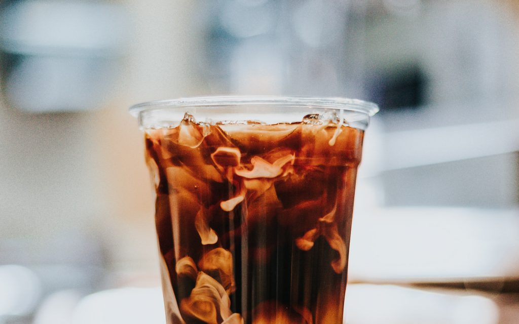 A takeaway cup of cold brew with milk at a coffee shop.