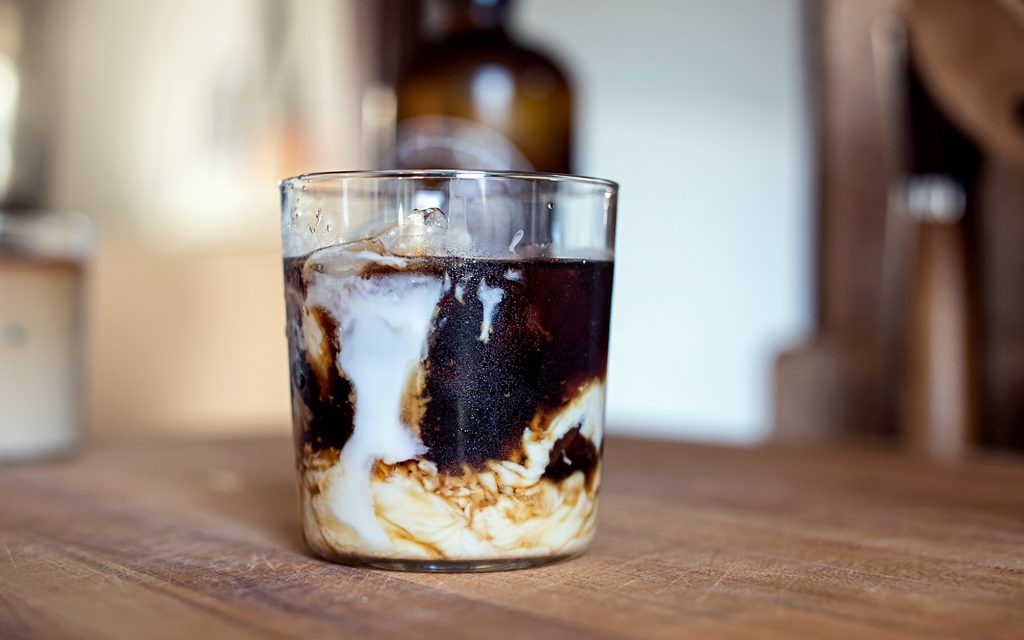 A glass of cold brew coffee with milk.