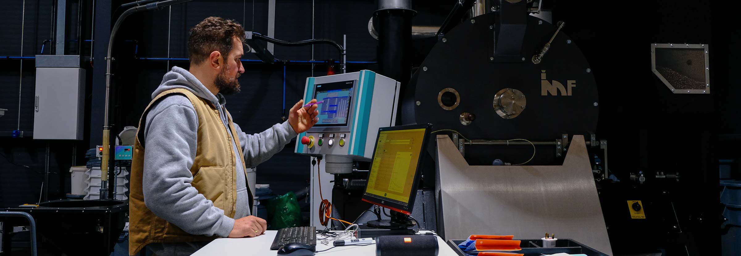 A professional coffee roaster checks the status of an ongoing roast.