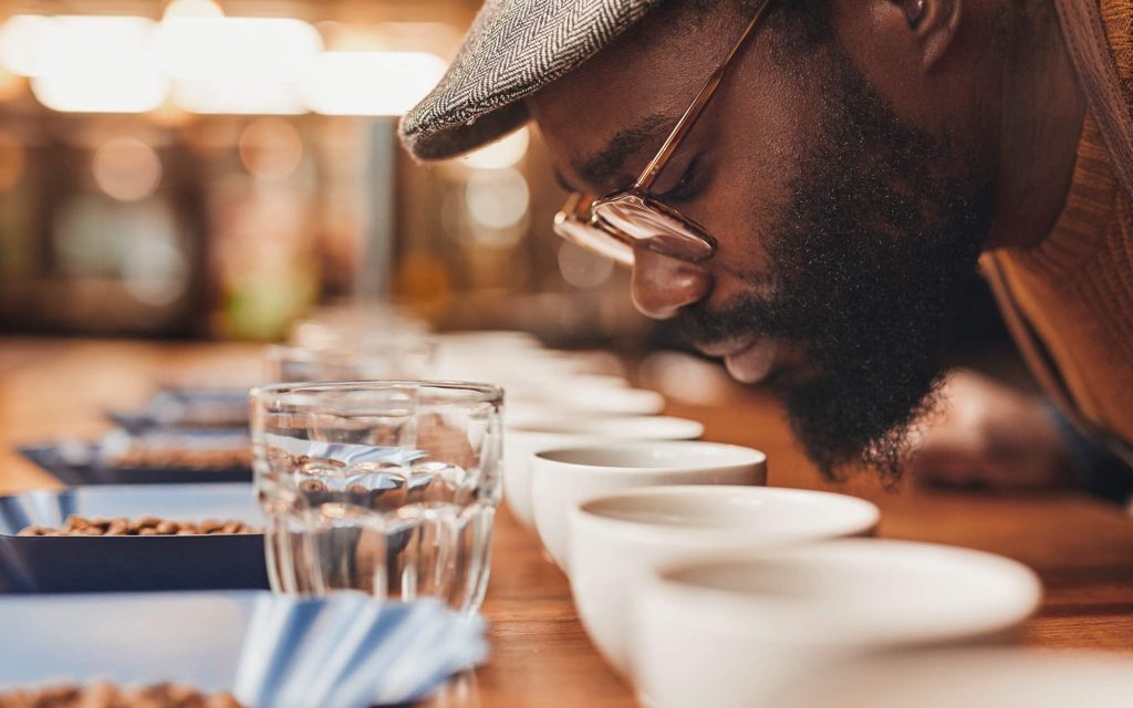 A man samples the aromas of various coffee beans at a café.