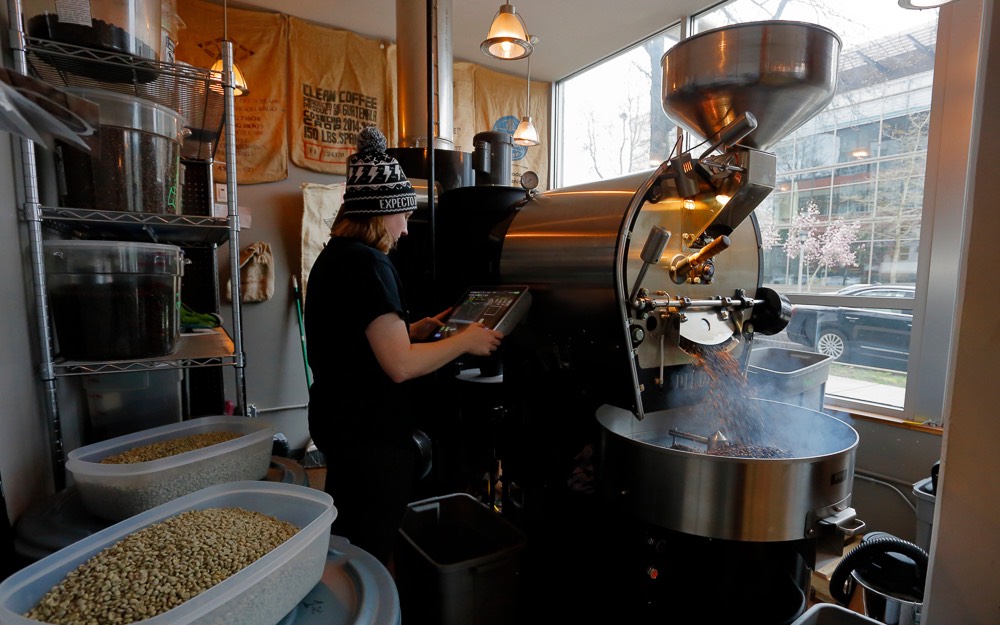 Torrefadora operando seu equipamento durante a torra de um lote de cafés para espresso.