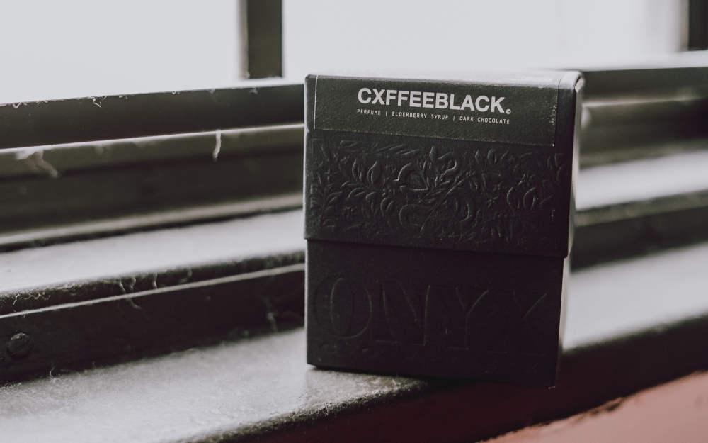 embalagem de café da marca Cxfeeblack sobre uma mesa