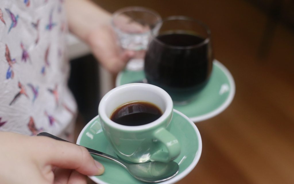 A barista explains the definition of specialty coffee to a customer.