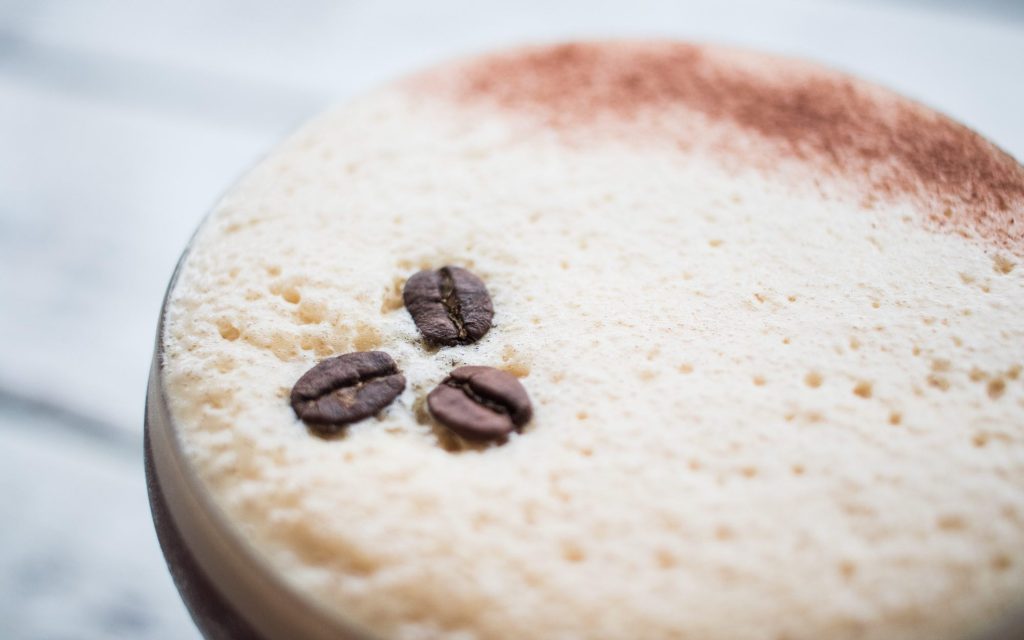 A coffee cocktail garnished with coffee beans.