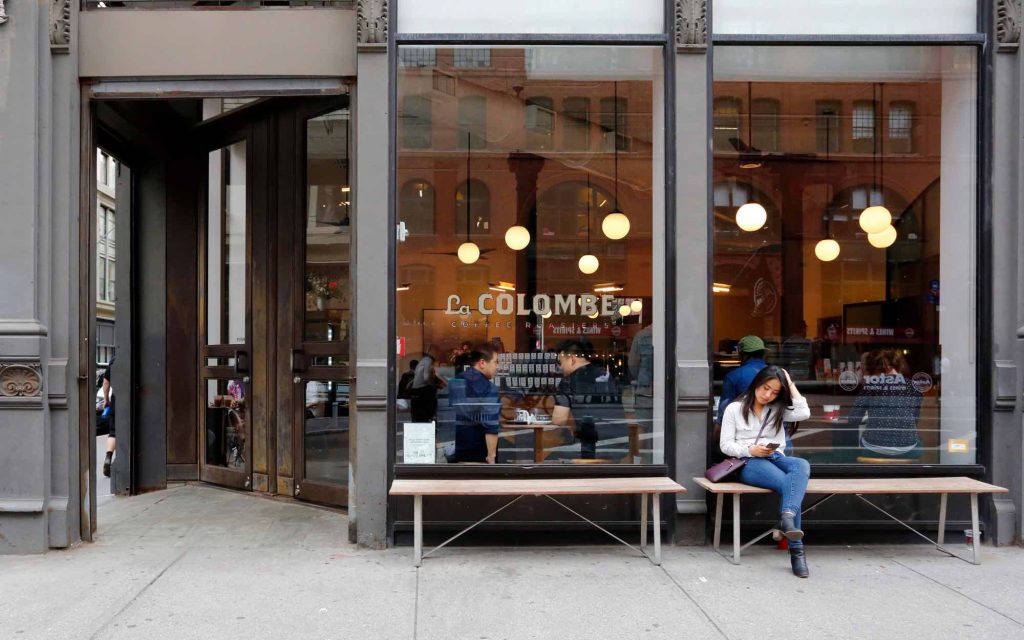 A customer sits outside a  La Colombe coffee shop in New York City.